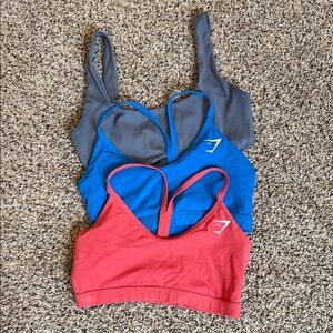 Gymshark Women’s sports bra: Set of 3. Gray, Blue, and Redish/pink. All size S